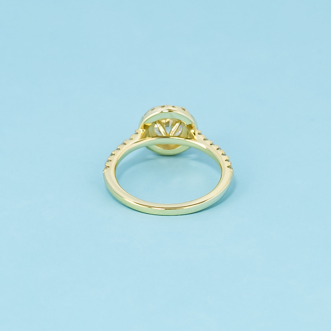 This elegant 9ct yellow gold ring features a round brilliant moissanite with a classic halo, perfect for a timeless engagement.