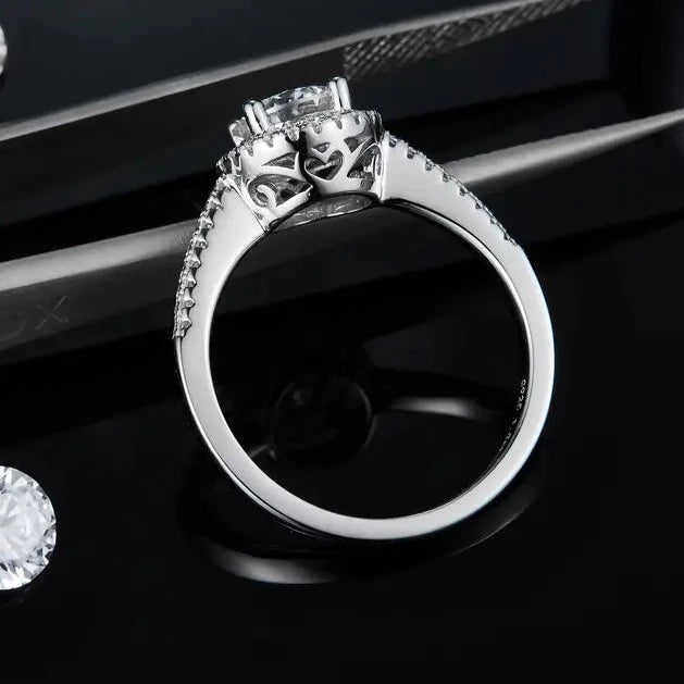 This 1.00ct moissanite engagement ring, with its charming heart halo, is the perfect symbol of love.