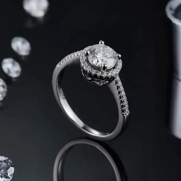 A captivating and romantic engagement ring featuring a sparkling 1.00ct moissanite and a delicate heart-shaped halo.