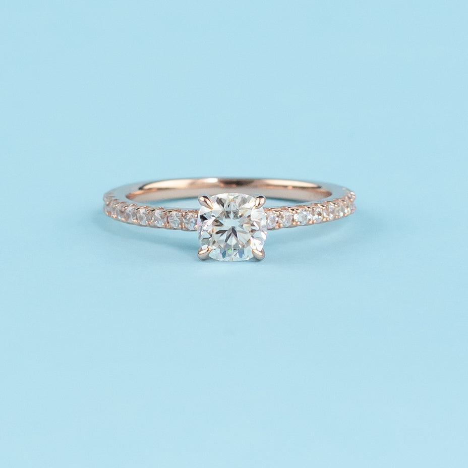 Elegant cushion cut moissanite engagement ring with a hidden halo setting, crafted in warm 9ct rose gold.