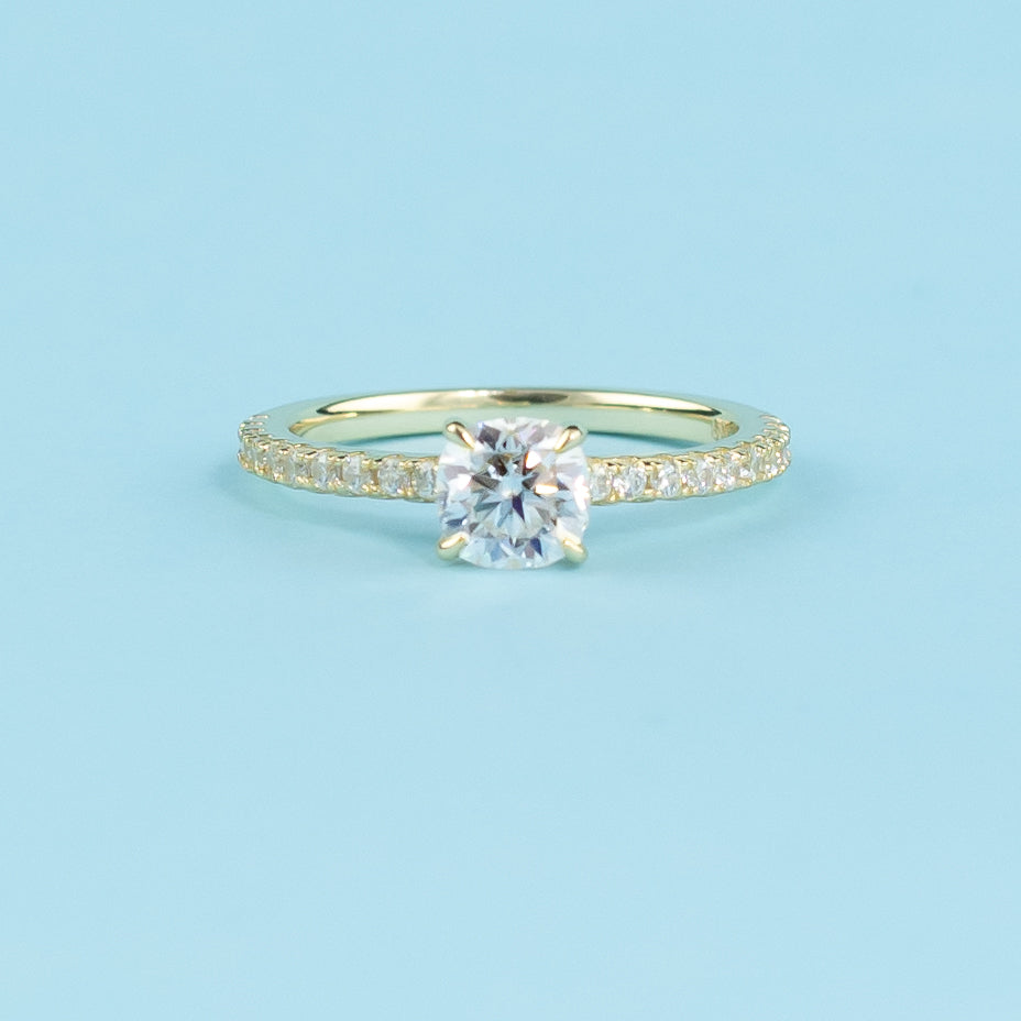 Showcases a beautiful cushion cut moissanite with a discreet hidden halo enhancing its brilliance.