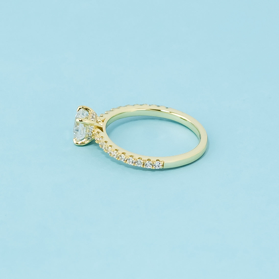This 9ct yellow gold ring features a classic cushion cut moissanite with a hidden halo detail.