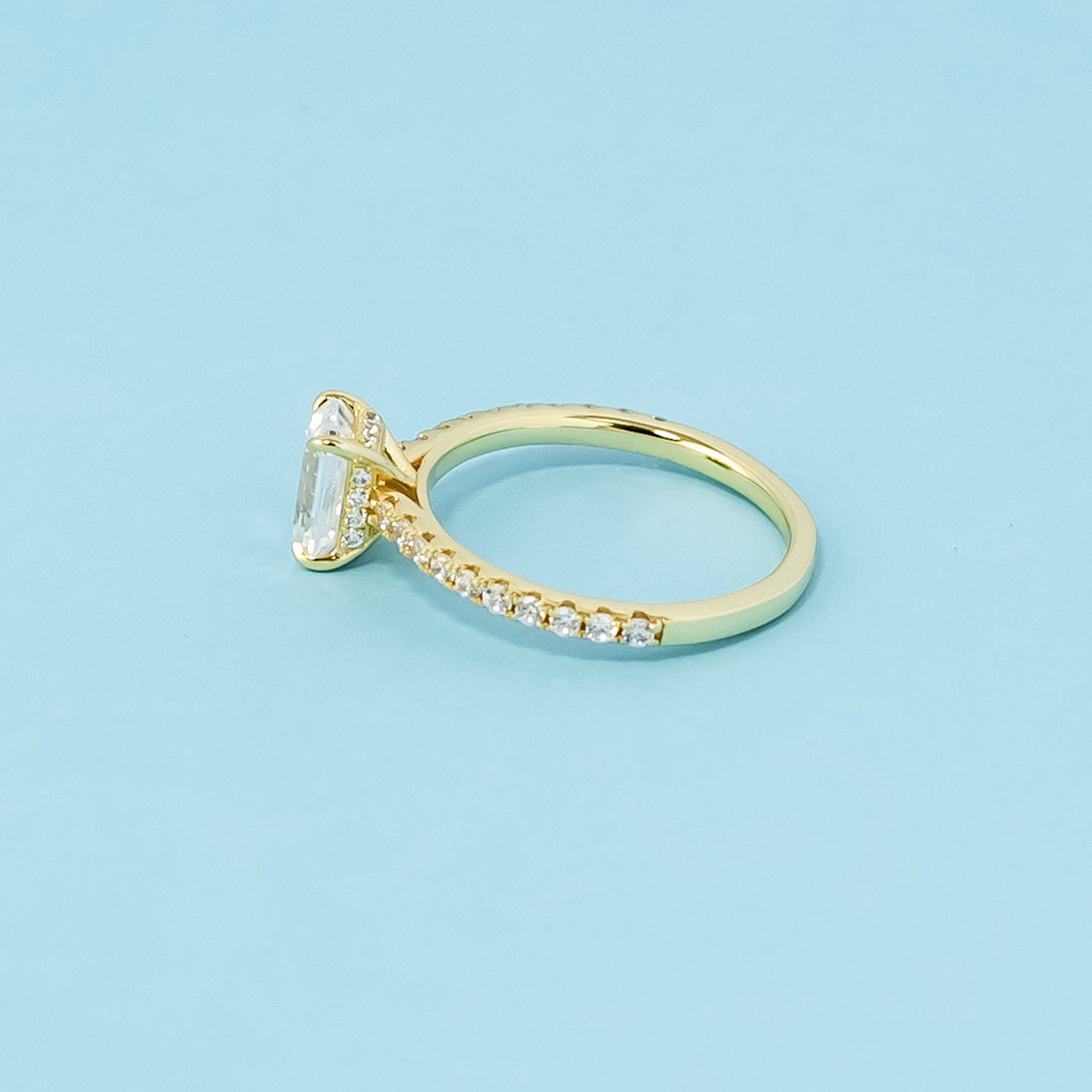 This 9ct yellow gold ring features a classic emerald cut moissanite with a secret, sparkling detail.