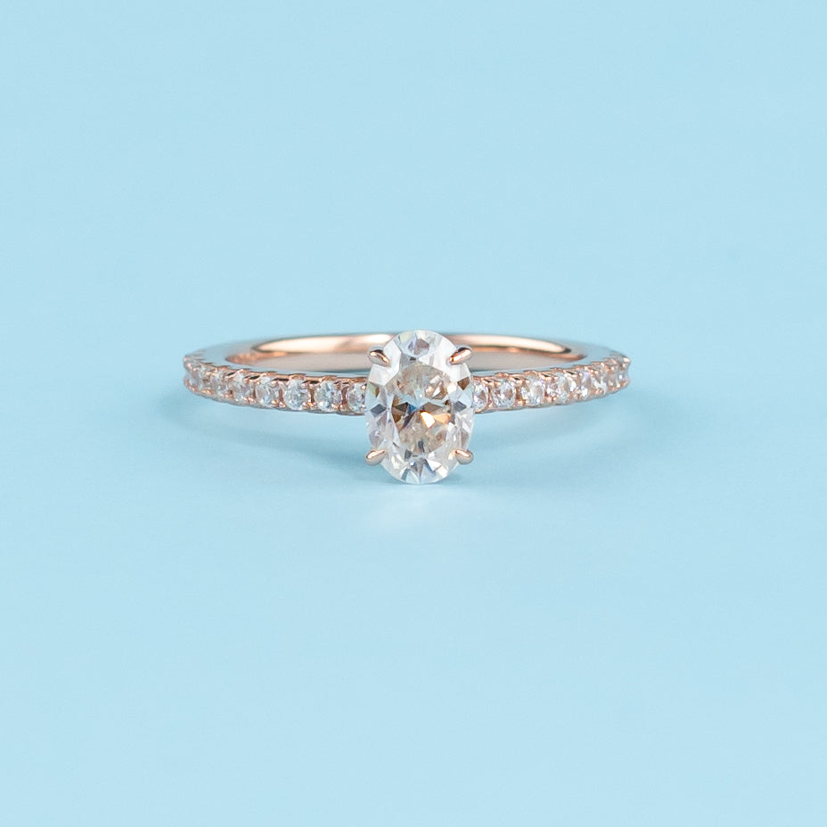 Elegant oval moissanite engagement ring with a hidden halo setting, crafted in warm 9ct rose gold.