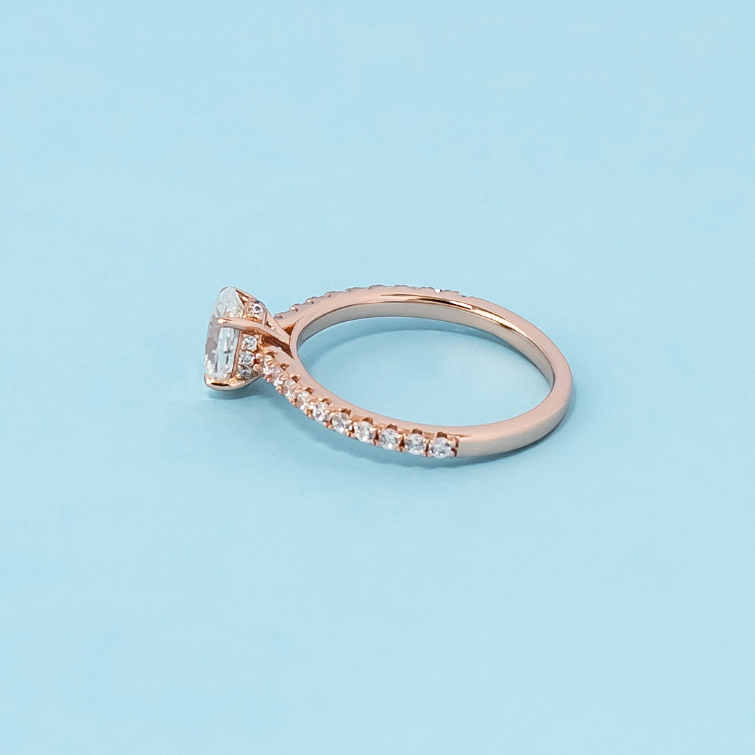 Stunning rose gold engagement ring featuring a sparkling oval cut moissanite and a unique hidden design.