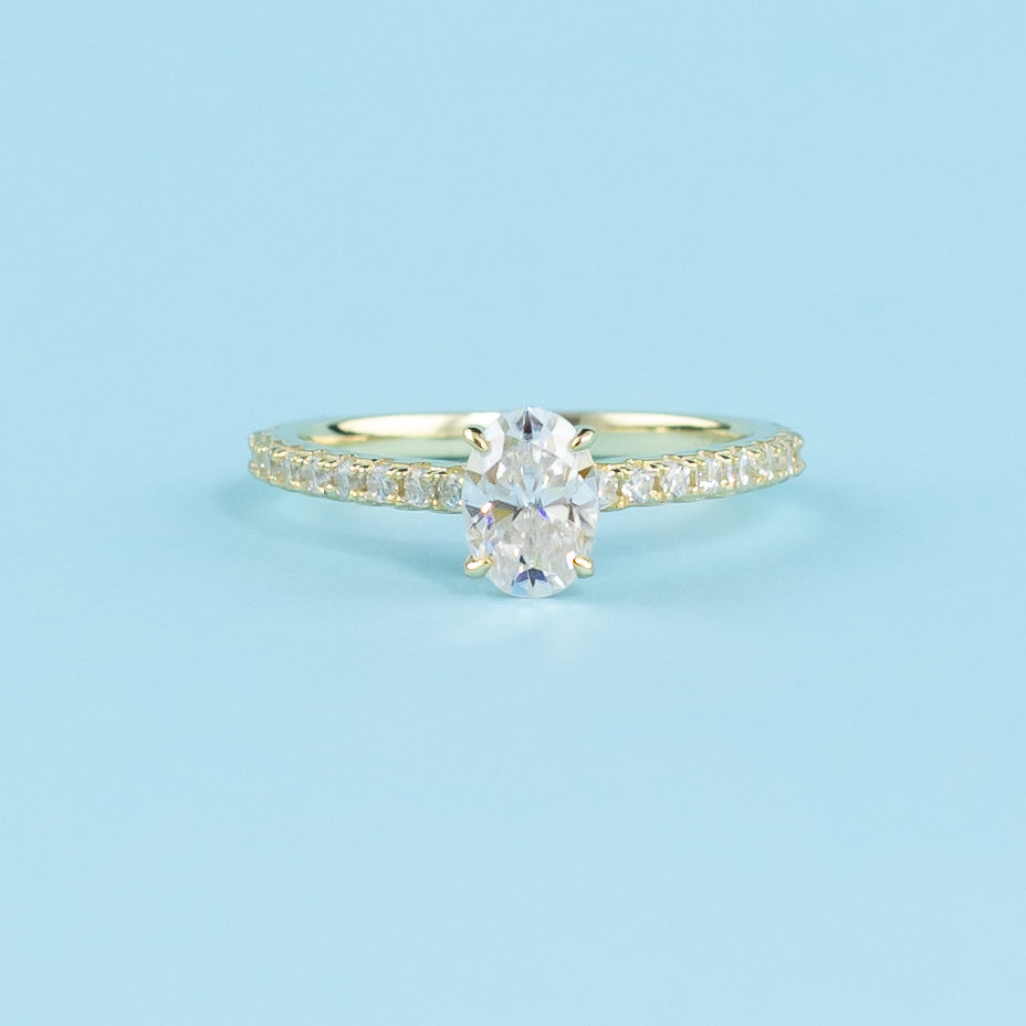 Showcases a beautiful oval cut moissanite with a discreet hidden halo enhancing its brilliance.