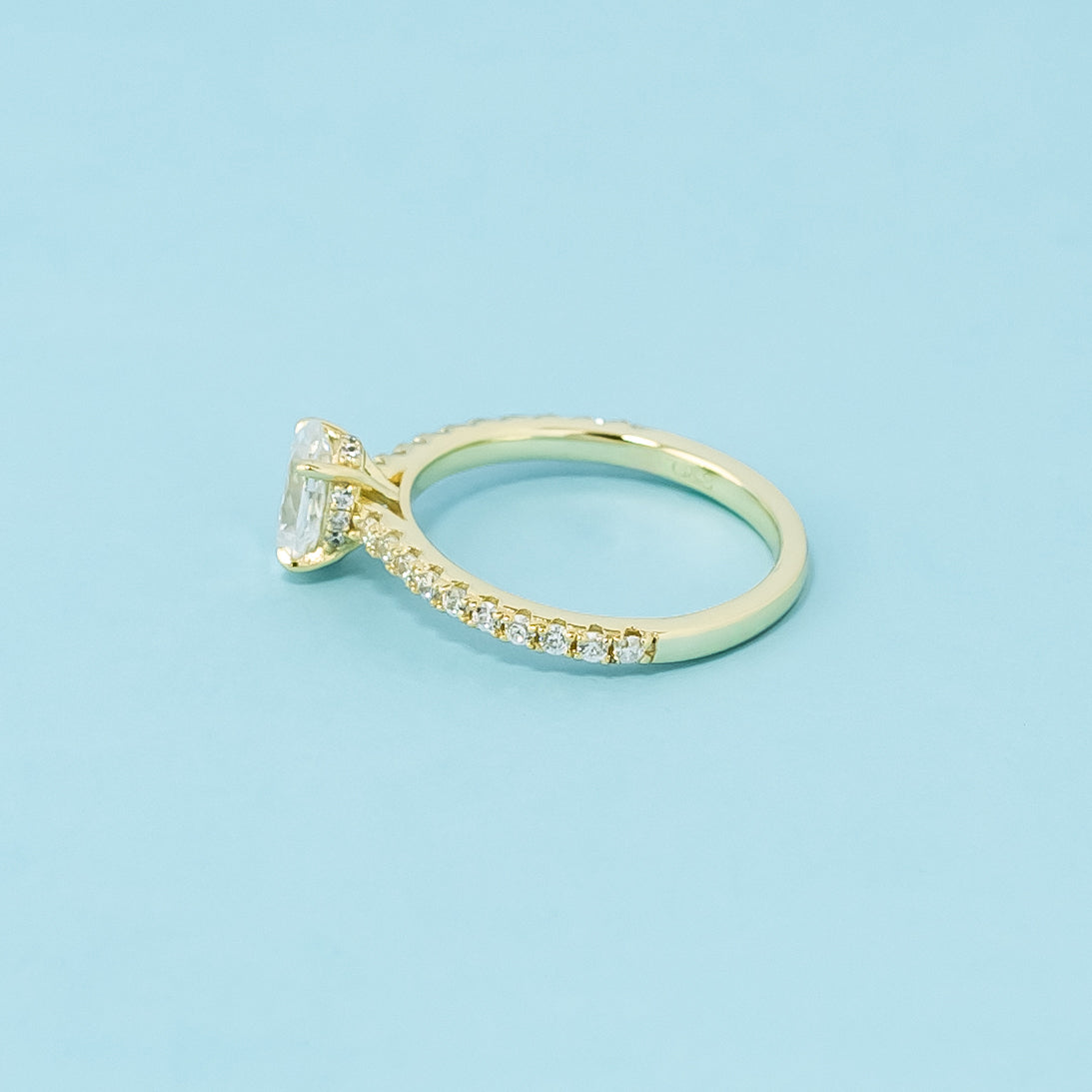 This 9ct yellow gold ring features a classic oval cut moissanite with a hidden halo detail.