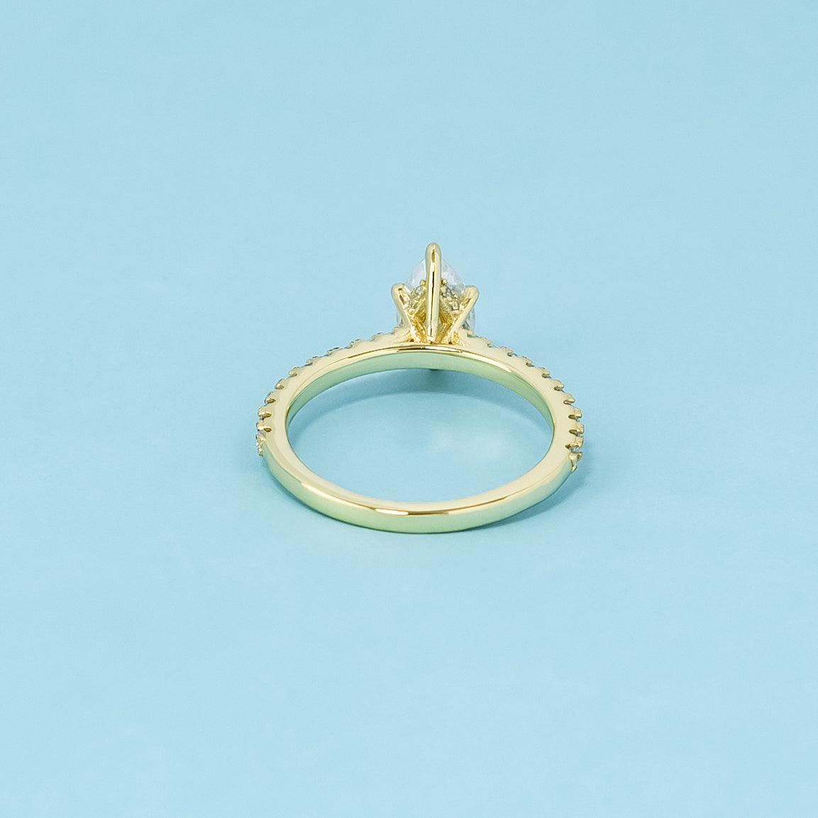 A sophisticated 9ct yellow gold engagement ring with a pear-shaped moissanite and a hidden halo for added elegance and shine.