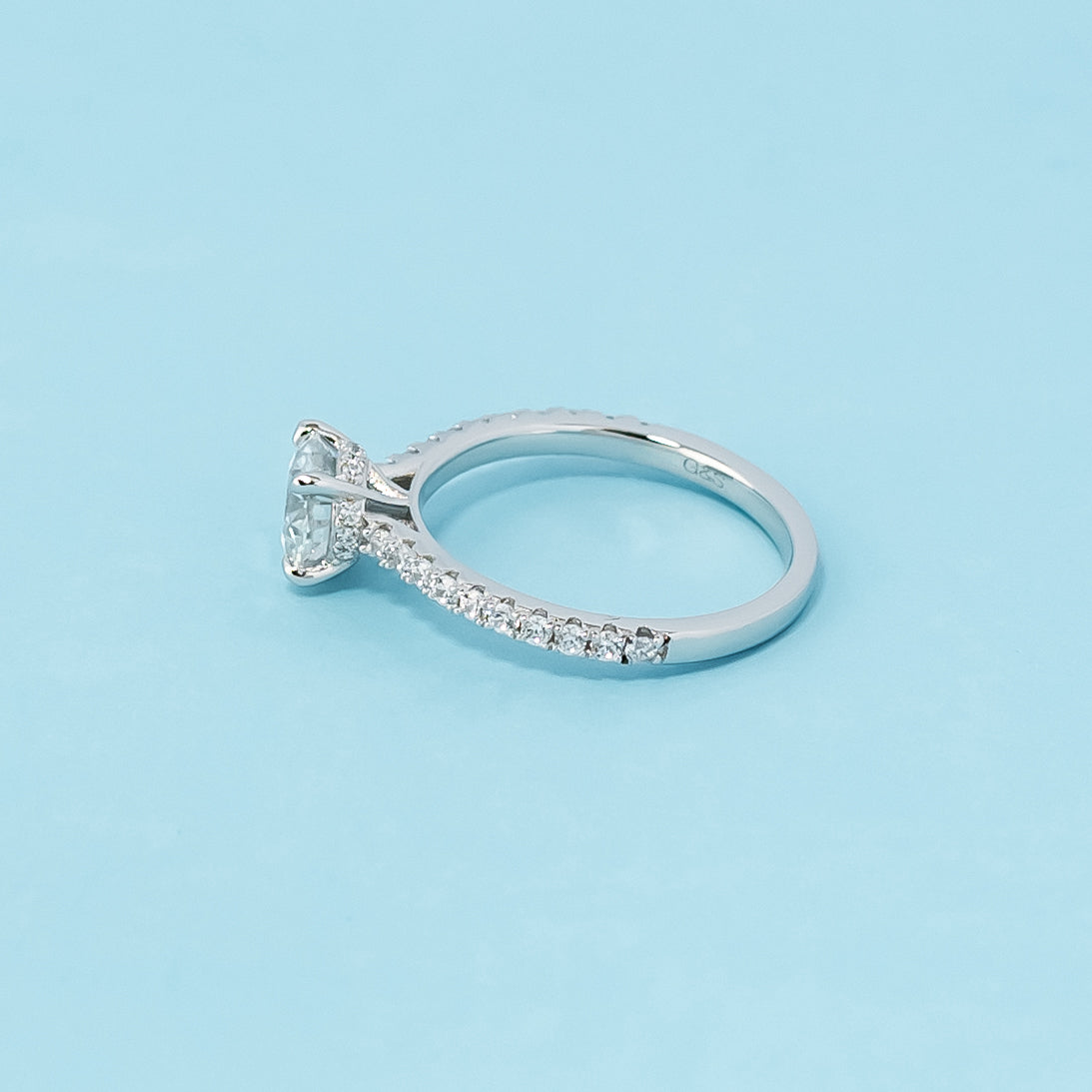 Modern and refined engagement ring showcasing a round brilliant moissanite in a unique hidden setting, crafted in 9ct white gold.

