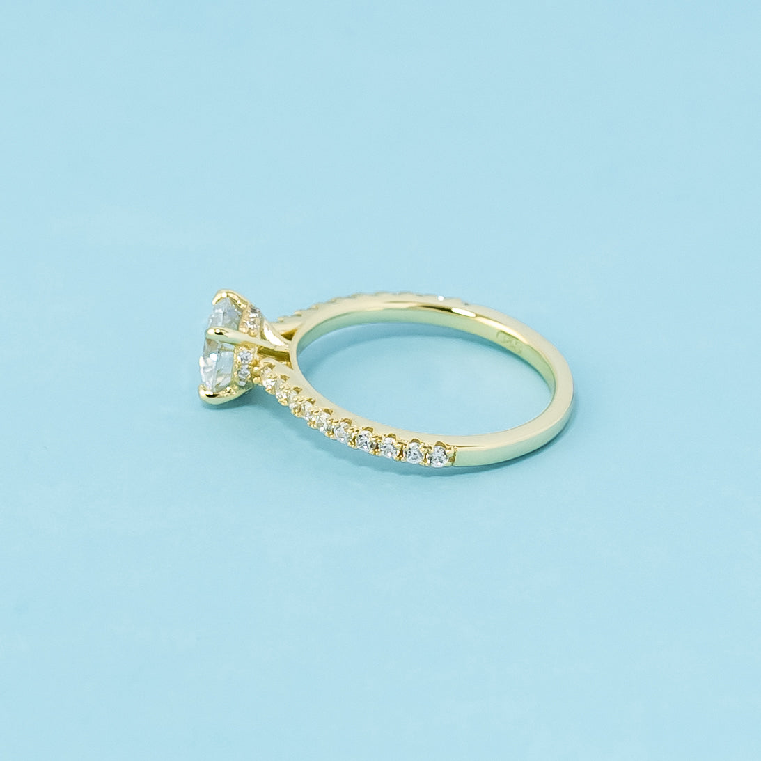 This 9ct yellow gold ring features a classic round brilliant moissanite with a hidden halo detail.