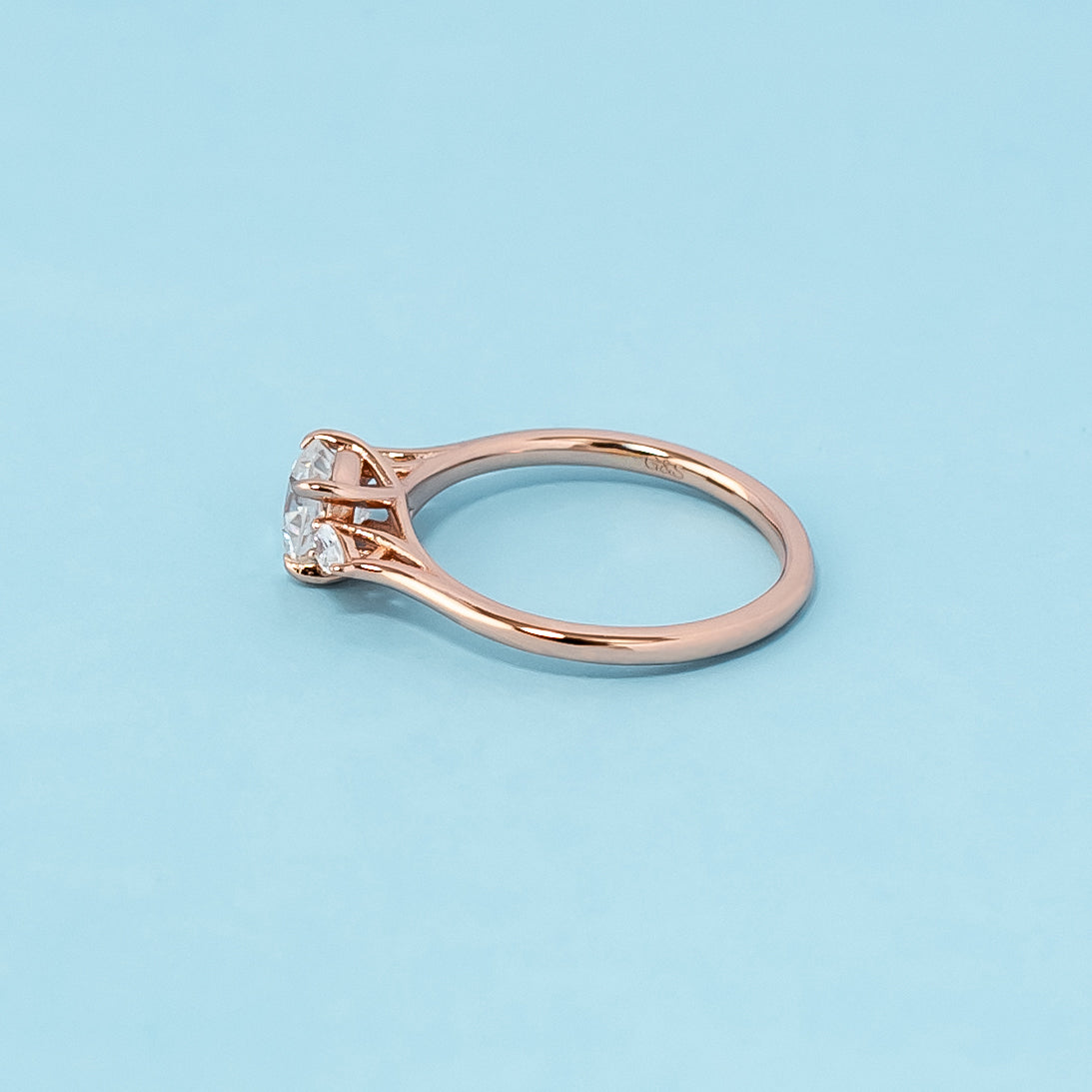 Elegant rose gold engagement ring showcasing three sparkling cushion cut moissanites in a classic trilogy design.