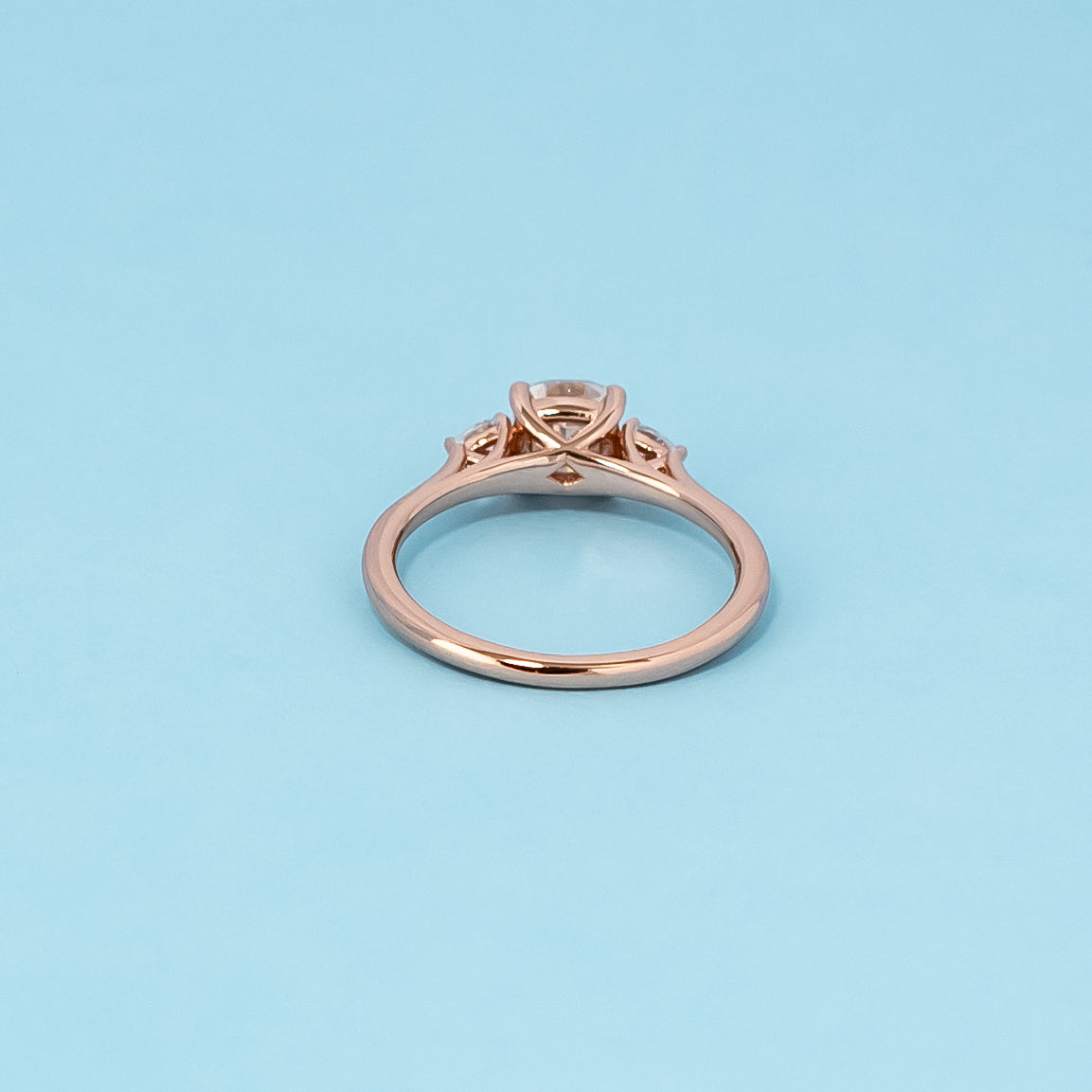 Luxurious 9ct rose gold engagement ring set featuring three beautiful cushion cut moissanites, representing enduring love.
