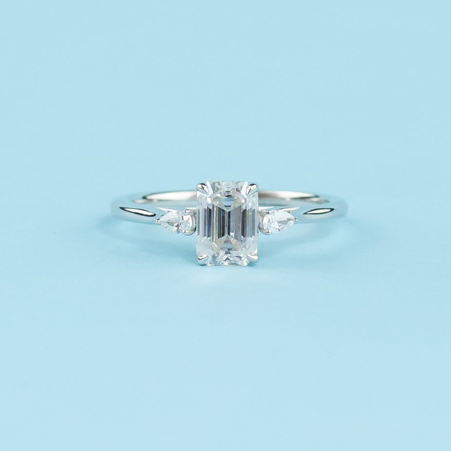 Elegant 9ct white gold engagement ring featuring three sparkling emerald cut moissanites in a trilogy design.