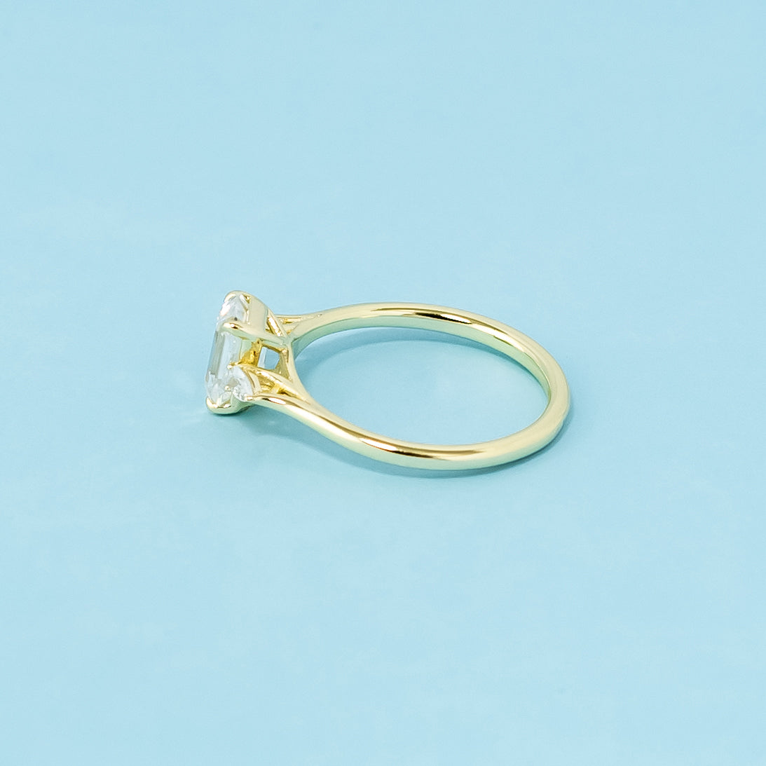 A classic trilogy ring with three brilliant emerald cut moissanites set in a beautiful 9ct yellow gold band.