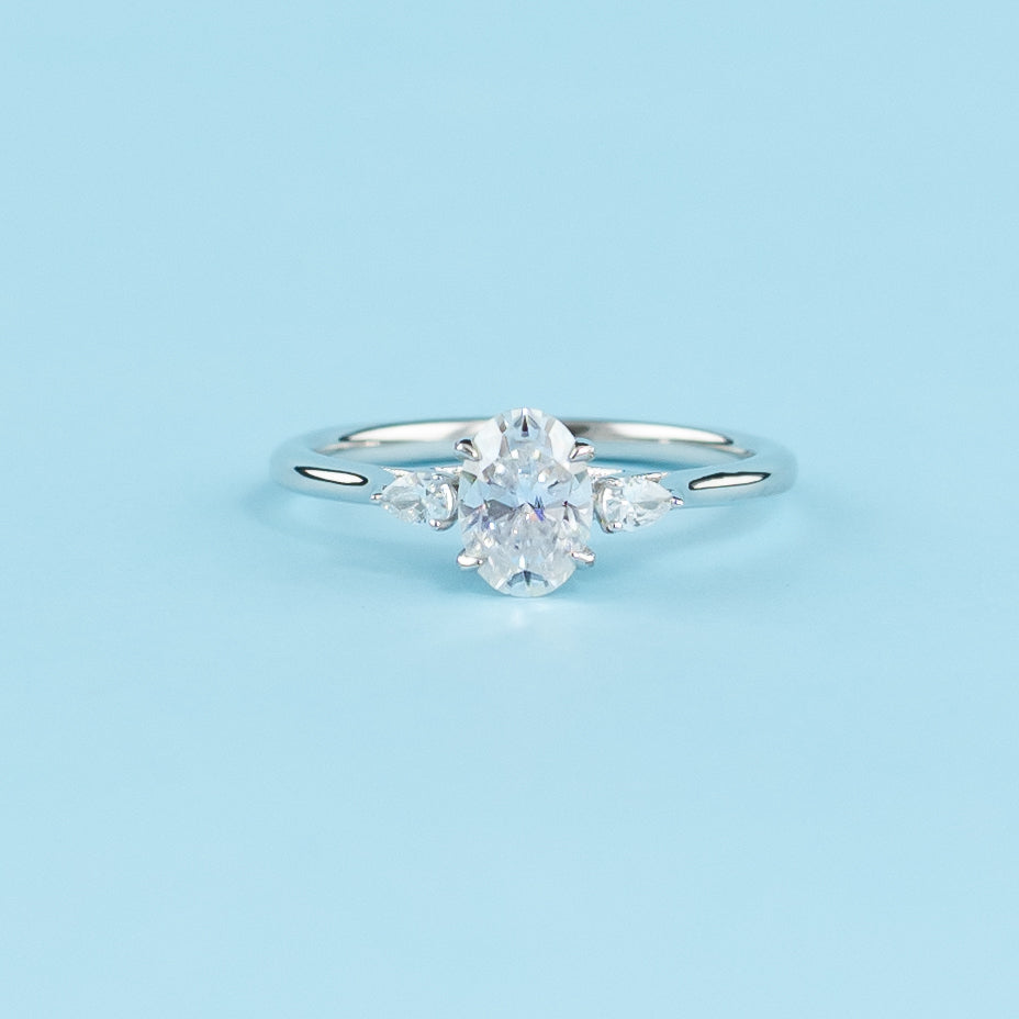 Elegant 9ct white gold engagement ring featuring a trilogy design with three sparkling oval cut moissanites.