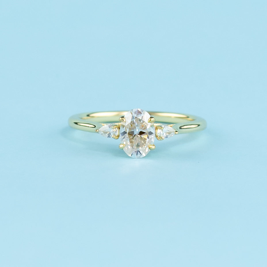 Three sparkling oval moissanites set in a warm 9ct yellow gold band, representing the past, present, and future.