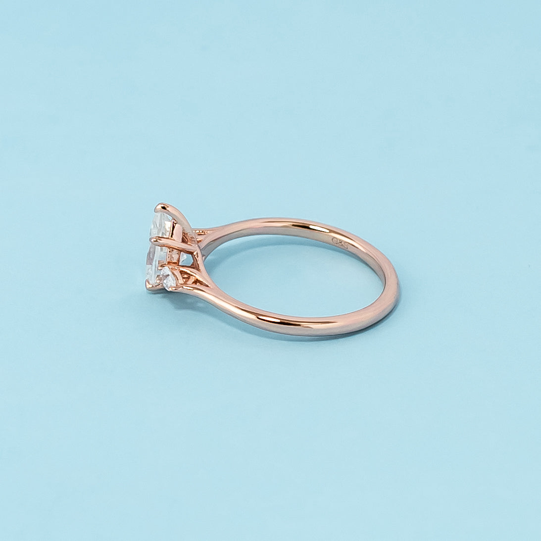 Elegant rose gold engagement ring showcasing three sparkling pear-shaped moissanites in a classic trilogy design.