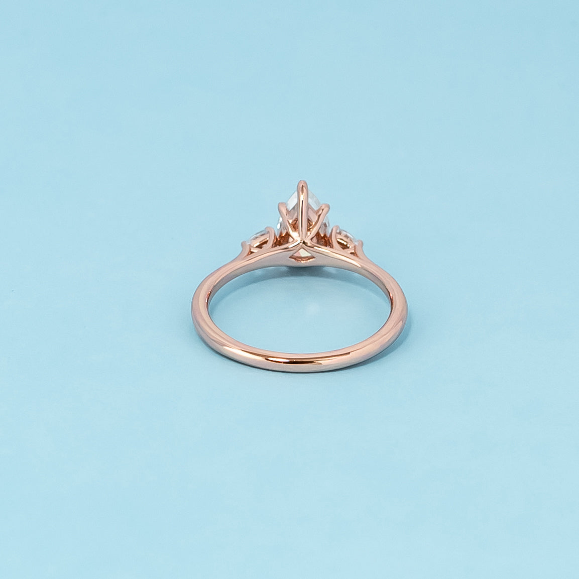 Luxurious 9ct rose gold engagement ring set featuring three beautiful pear-shaped moissanites, representing enduring love.