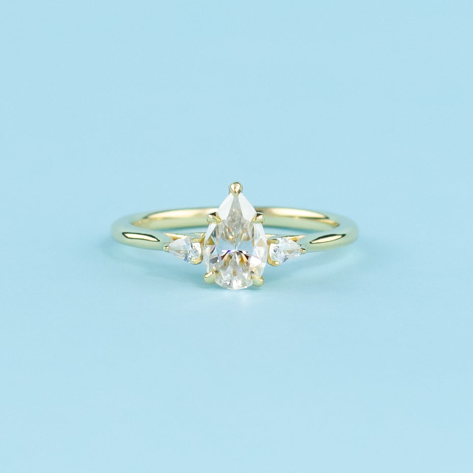 Three sparkling pear-shaped moissanites set in a warm and classic 9ct yellow gold design.