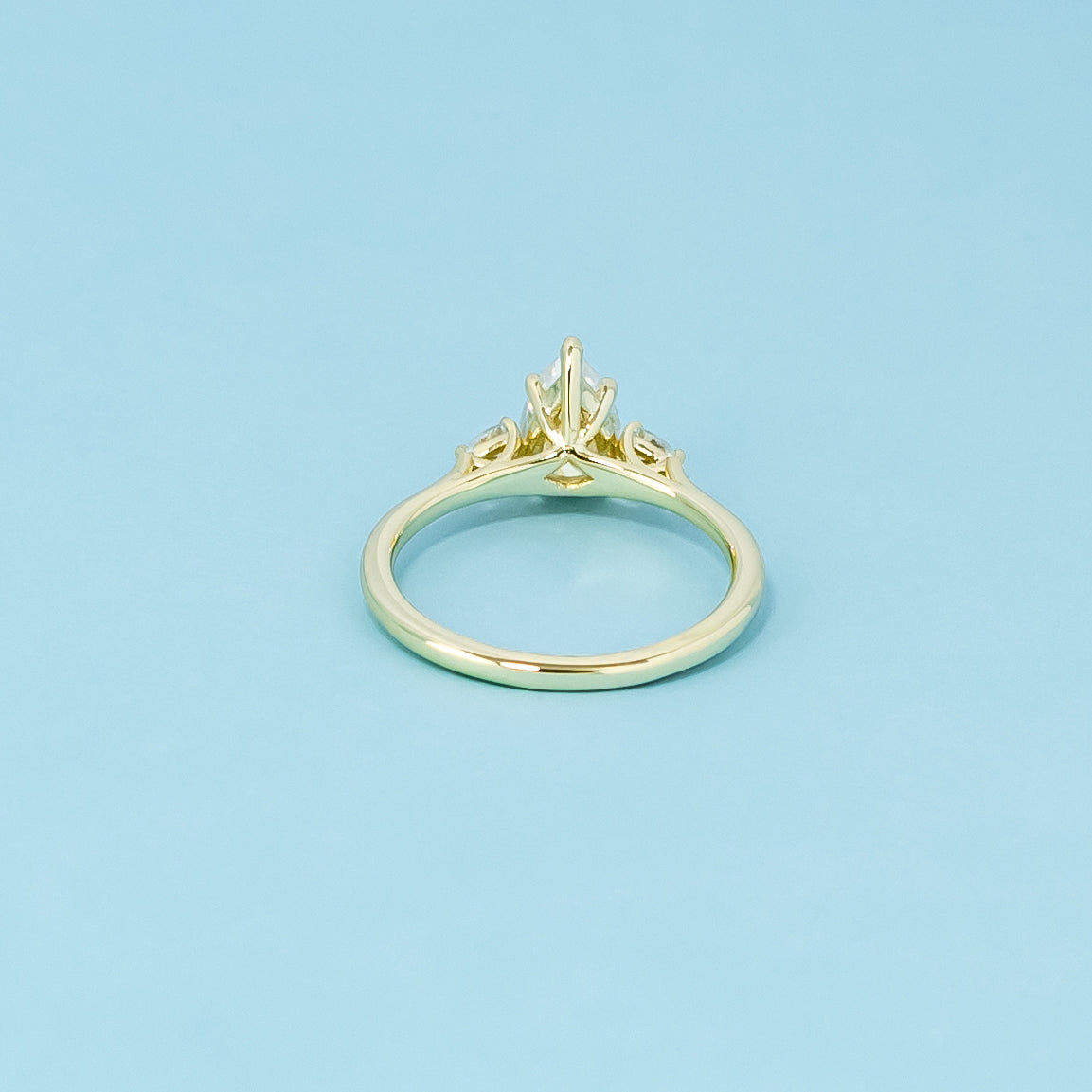 This ring beautifully showcases three pear-shaped moissanites in a 9ct yellow gold setting symbolizing everlasting love.