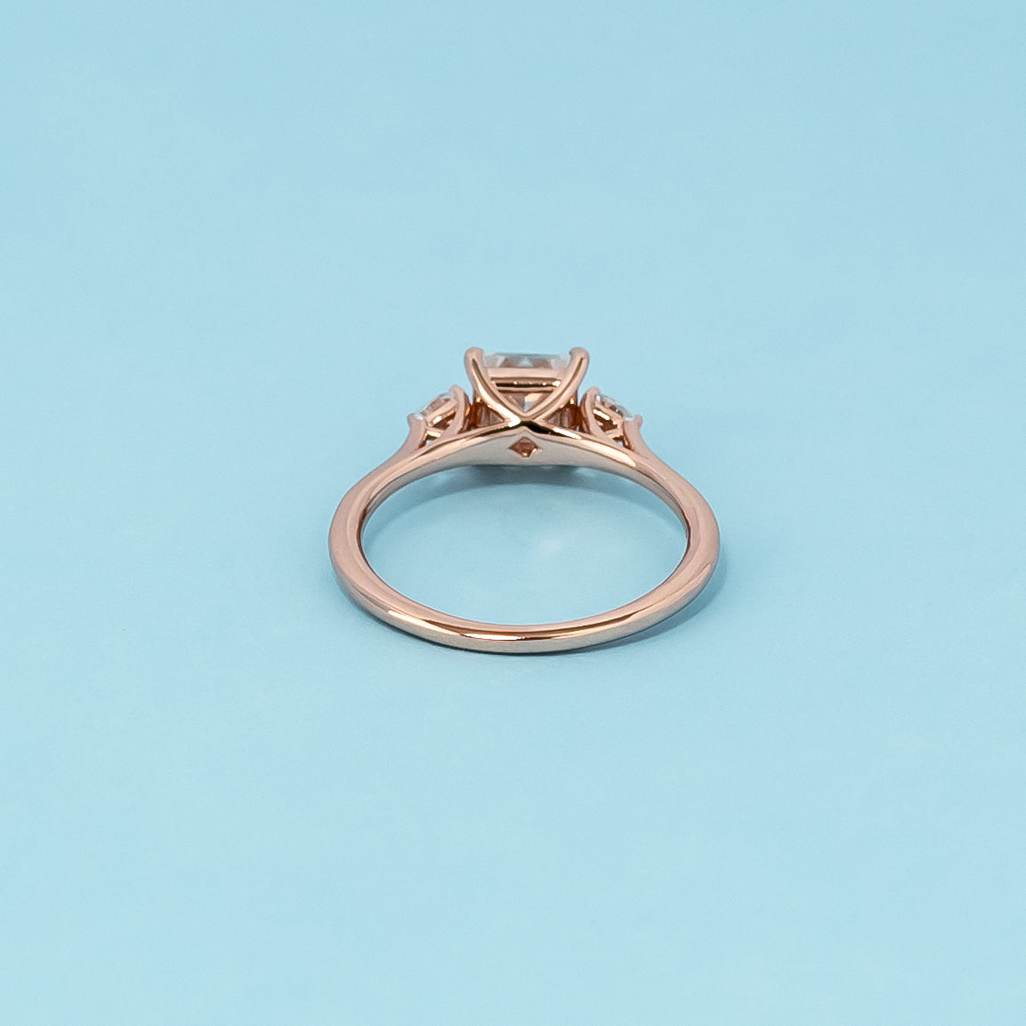Luxurious 9ct rose gold engagement ring set showcasing three beautiful princess cut moissanites, symbolizing enduring love.