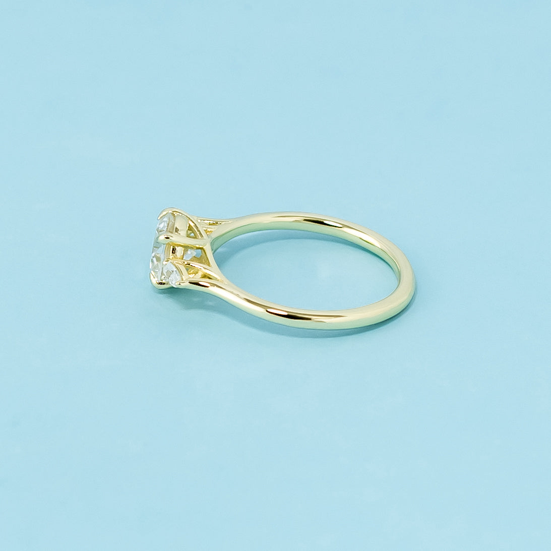 This 9ct yellow gold ring features a classic trilogy design with three beautifully cut round brilliant moissanites.