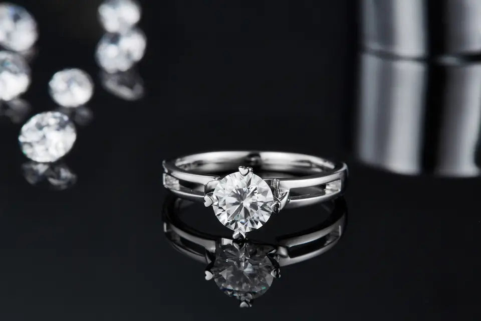 This engagement ring features a stunning 1.00ct moissanite and a sterling silver band fashioned into an infinity symbol, representing everlasting commitment.