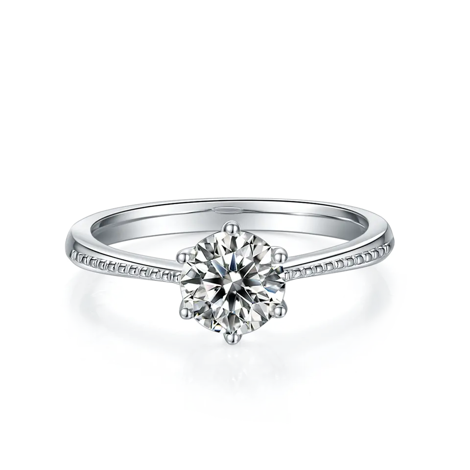 This elegant ring showcases a sparkling 1.00ct moissanite held by six prongs, set on a sterling silver band adorned with vintage-inspired milgrain.