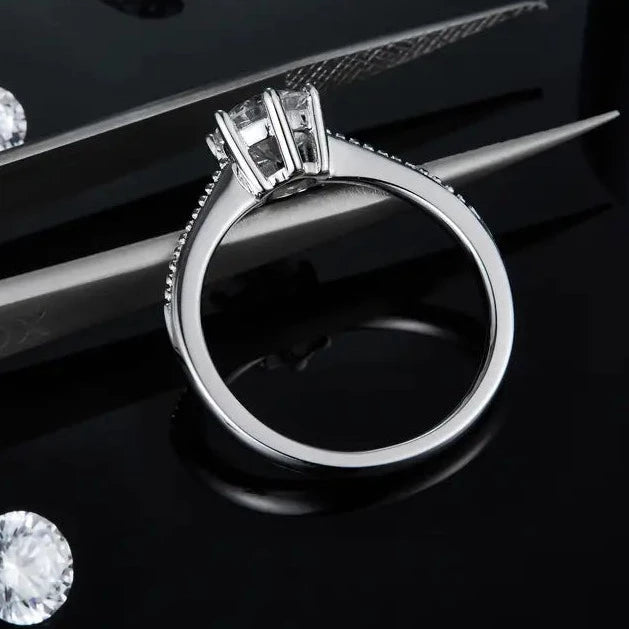 This sterling silver engagement ring features a stunning 1.00ct moissanite in a secure six-prong setting, highlighted by fine milgrain detailing along the band.