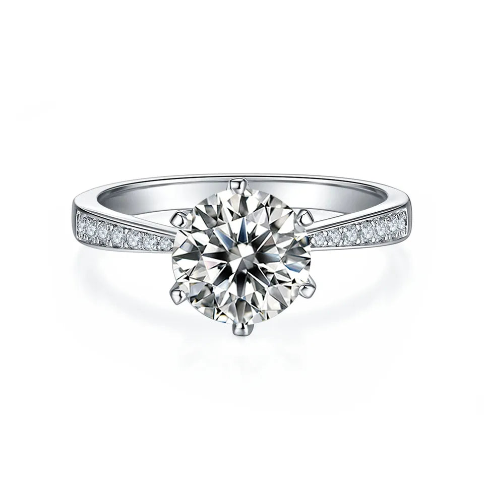 This ring features a 2.00ct moissanite held by a classic 6-prong Tiffany setting, complemented by a sparkling pave band in sterling silver.