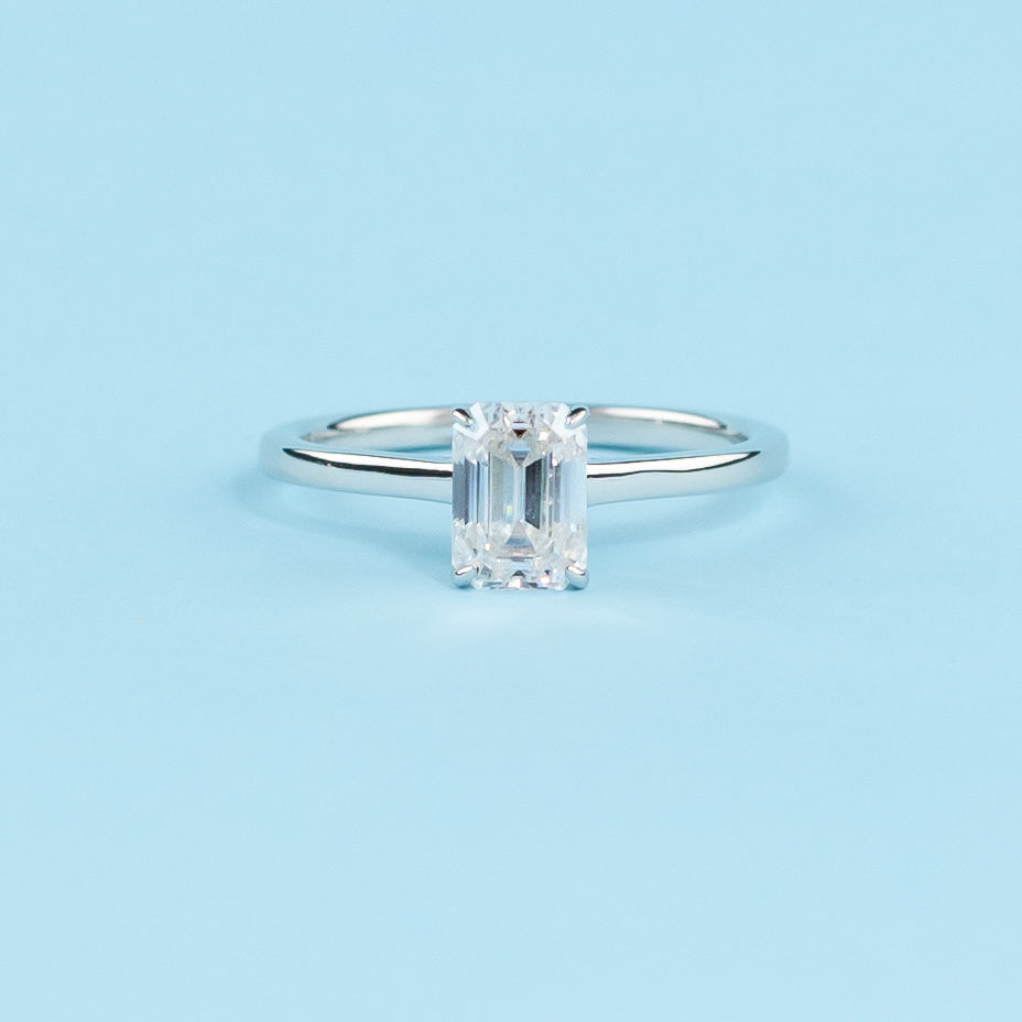 Elegant 9ct white gold engagement ring featuring an emerald cut moissanite with a hidden halo for extra sparkle.
