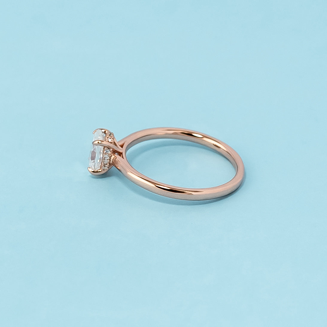Stunning rose gold engagement ring featuring a sparkling oval cut moissanite and a secret sparkle hidden halo design.