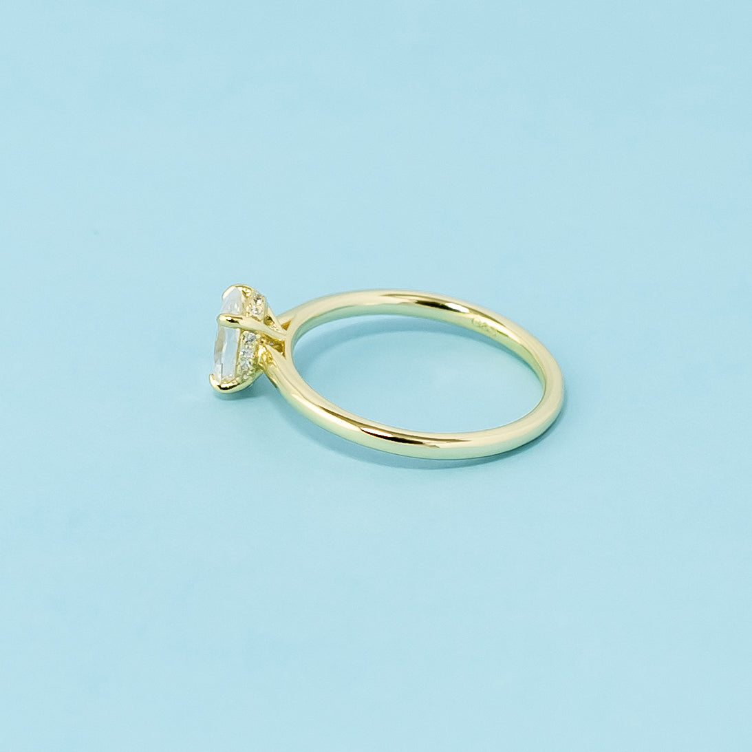 This 9ct yellow gold ring features a classic oval moissanite with a hidden halo for a touch of unexpected brilliance.