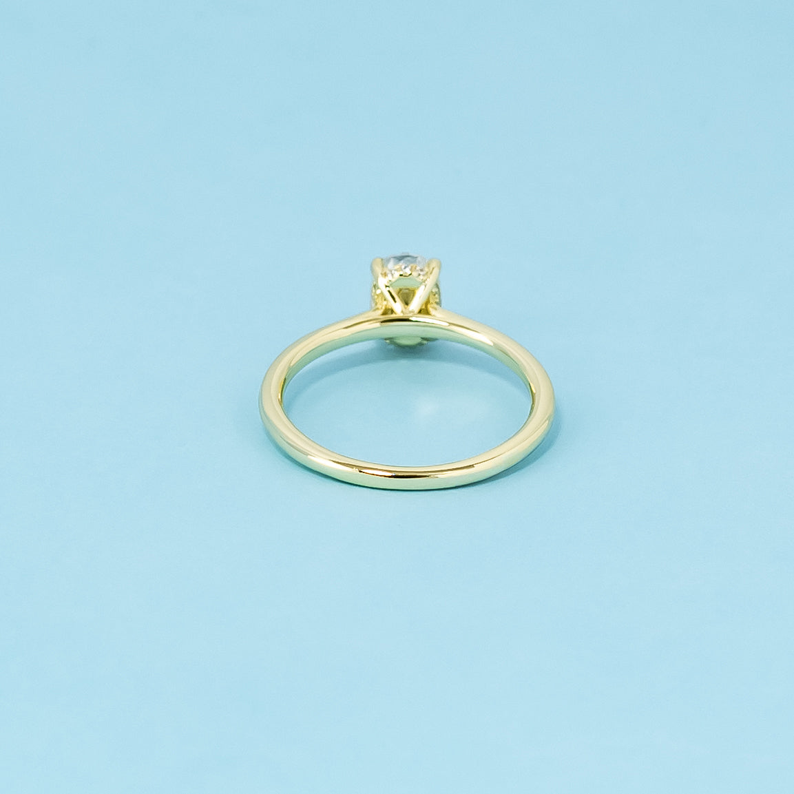 Indulge in the subtle elegance of this 9ct yellow gold ring, featuring an oval moissanite with a discreet hidden halo.