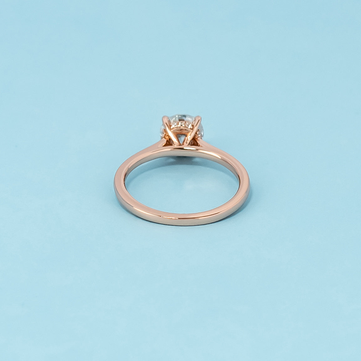 Luxurious 9ct rose gold engagement ring showcasing a brilliant round brilliant moissanite with a subtle and dazzling hidden halo.