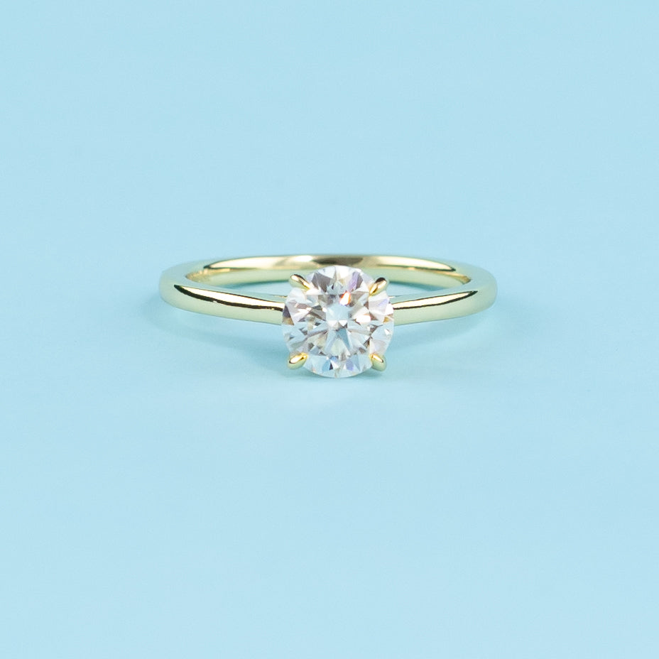 Discover the secret sparkle with this elegant ring, featuring a round brilliant moissanite enhanced by a hidden halo.
