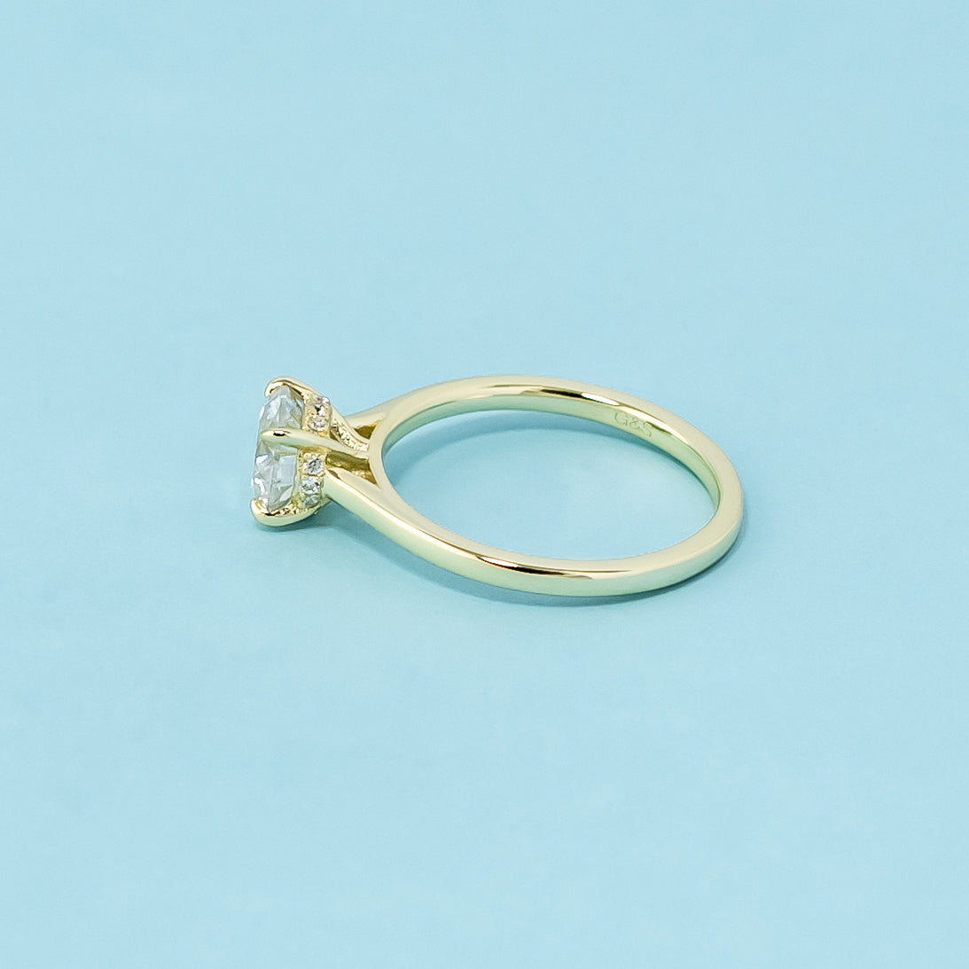 This 9ct yellow gold ring features a classic round brilliant moissanite with a hidden halo for a touch of unexpected brilliance.