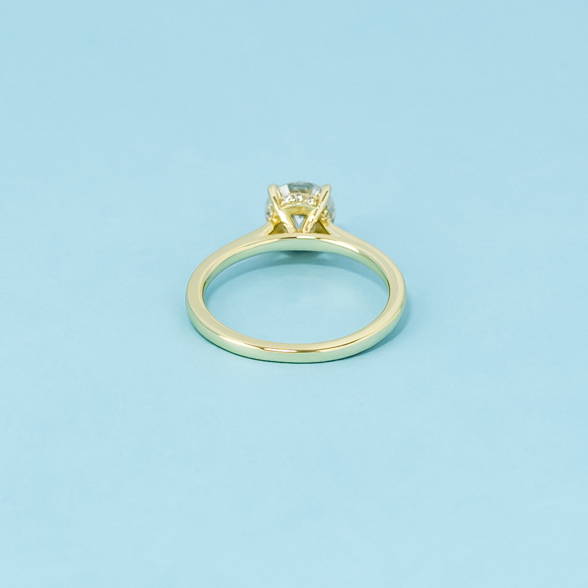 Indulge in the subtle elegance of this 9ct yellow gold ring, featuring a round brilliant moissanite with a discreet hidden halo.