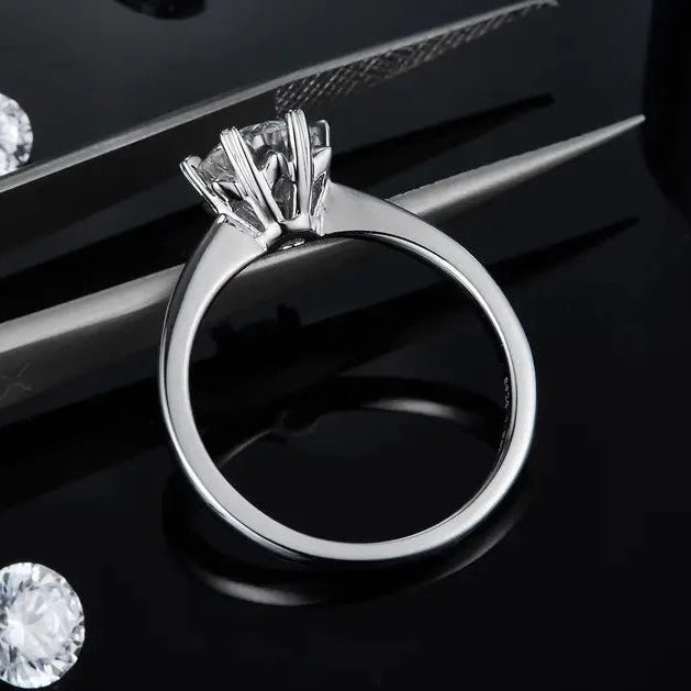 A timeless engagement ring in sterling silver, featuring a 1.00ct moissanite held by six heart-shaped prongs, adding a subtle touch of romance.