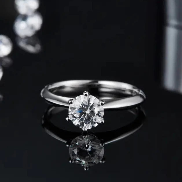 A close-up view of a sterling silver engagement ring featuring a 1.00ct moissanite held by six elegant prongs.