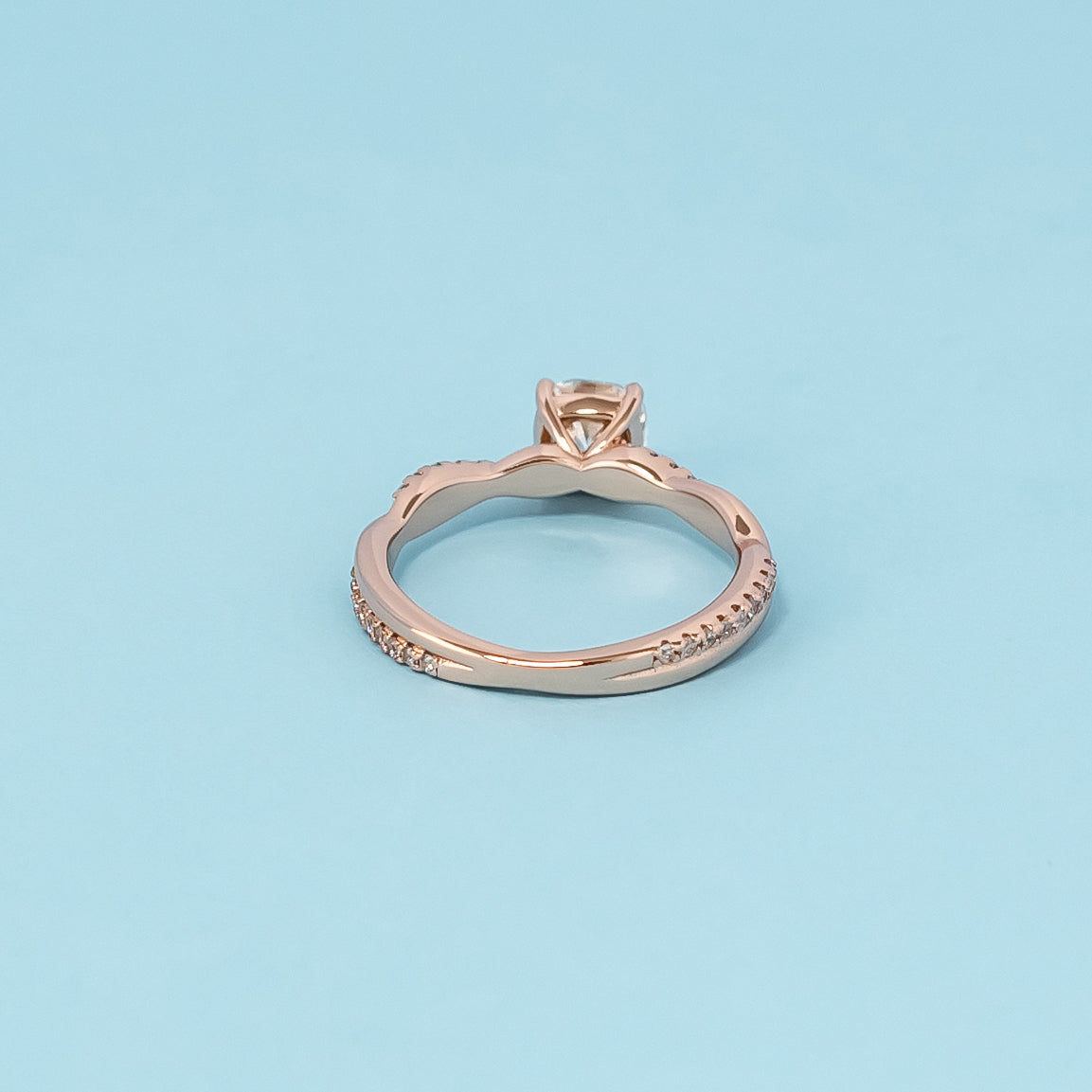 Luxurious 9ct rose gold engagement ring showcasing a beautiful cushion cut moissanite in a timeless infinity setting.