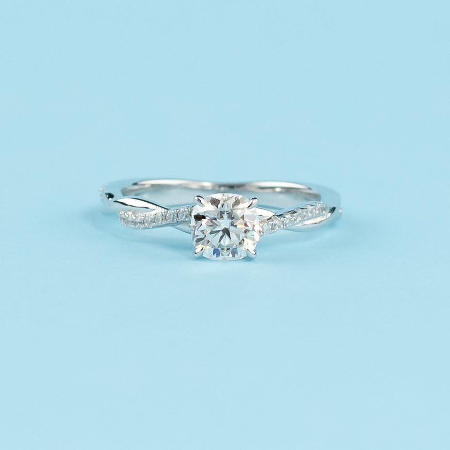 Elegant 9ct White Gold Cushion Cut Moissanite Engagement Ring with Infinity Band:  A beautiful cushion-cut moissanite engagement ring set in a delicate 9ct white gold band with an infinity design.
