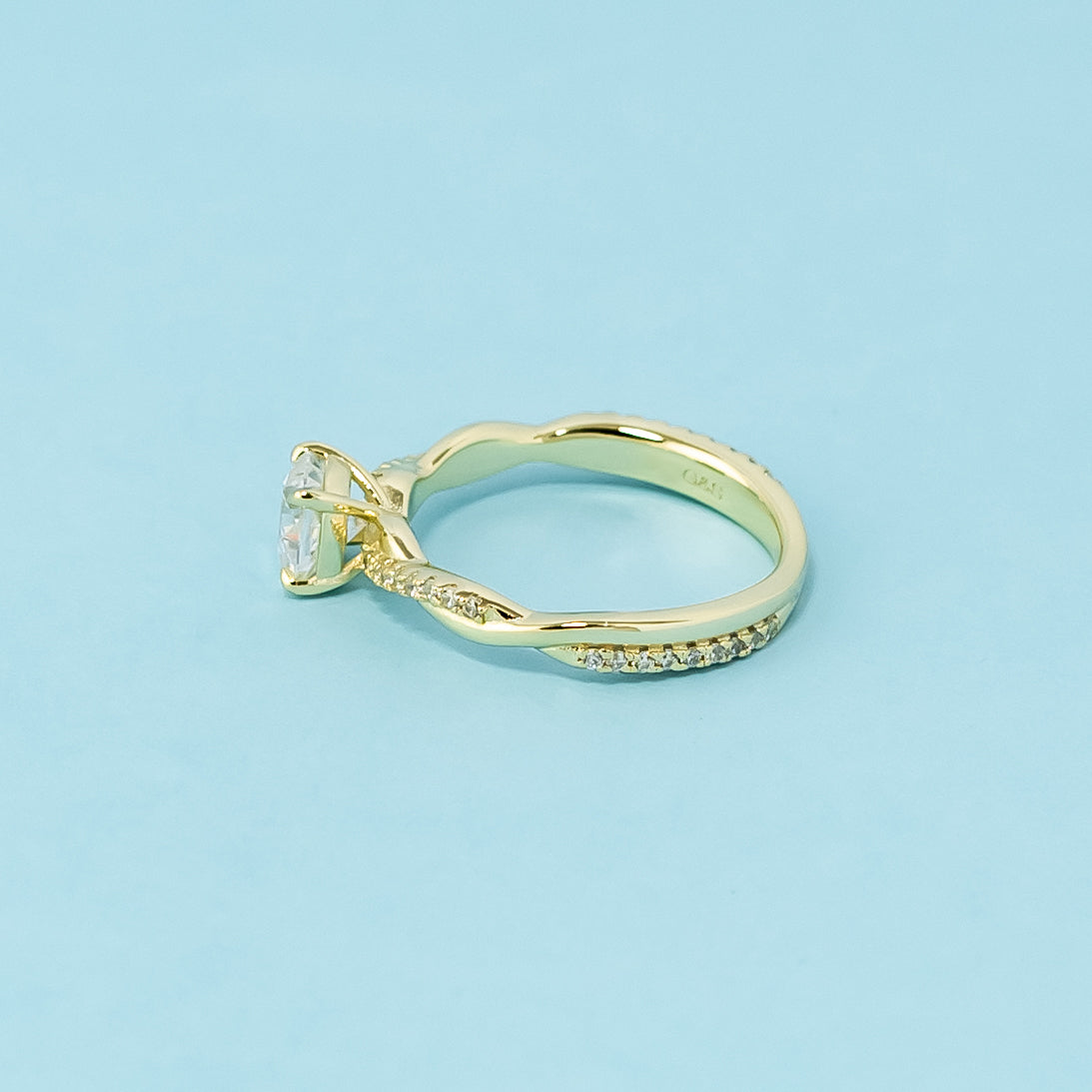 This 9ct yellow gold ring features a classic cushion cut moissanite with a delicate infinity design element.