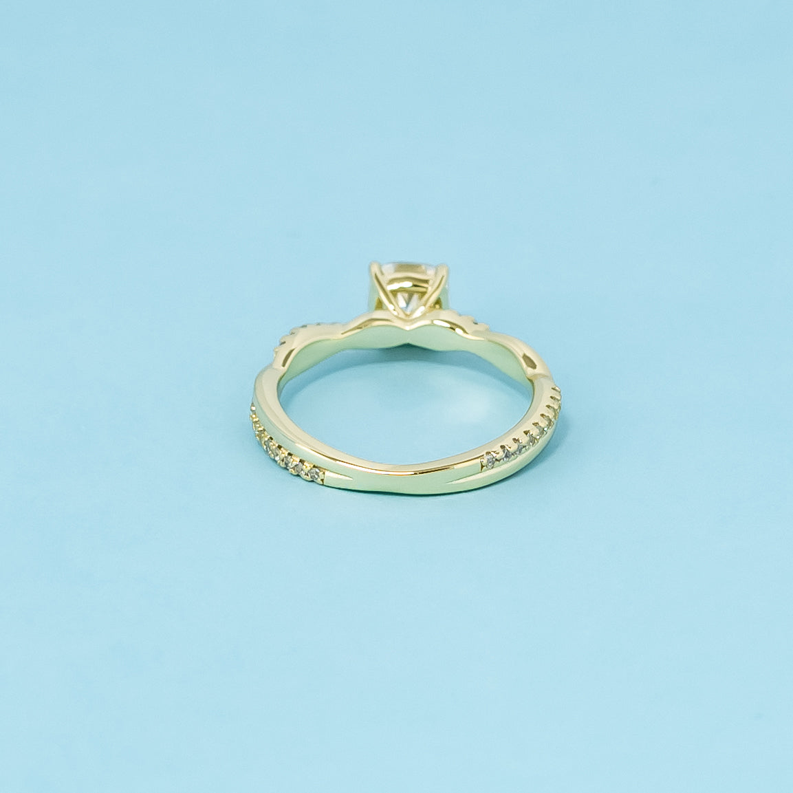 A symbol of everlasting love, this 9ct yellow gold ring features a cushion cut moissanite and a flowing infinity design.