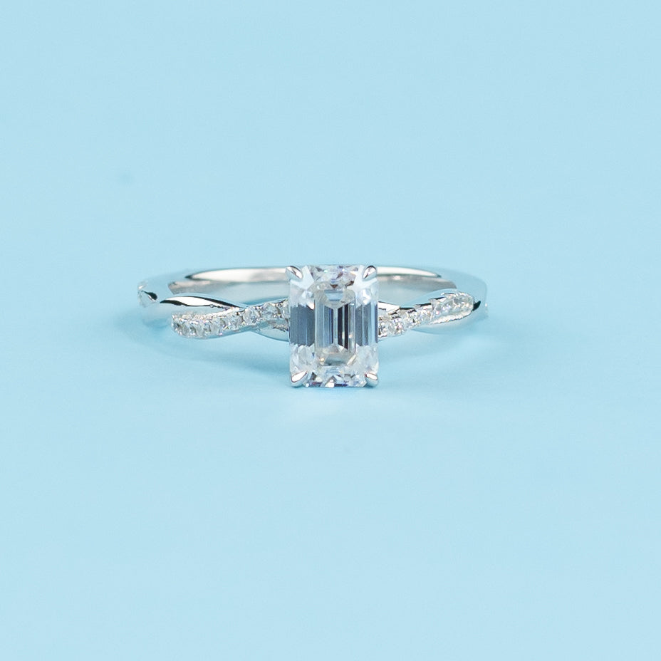 Elegant 9ct white gold engagement ring featuring an emerald cut moissanite in a timeless infinity design.