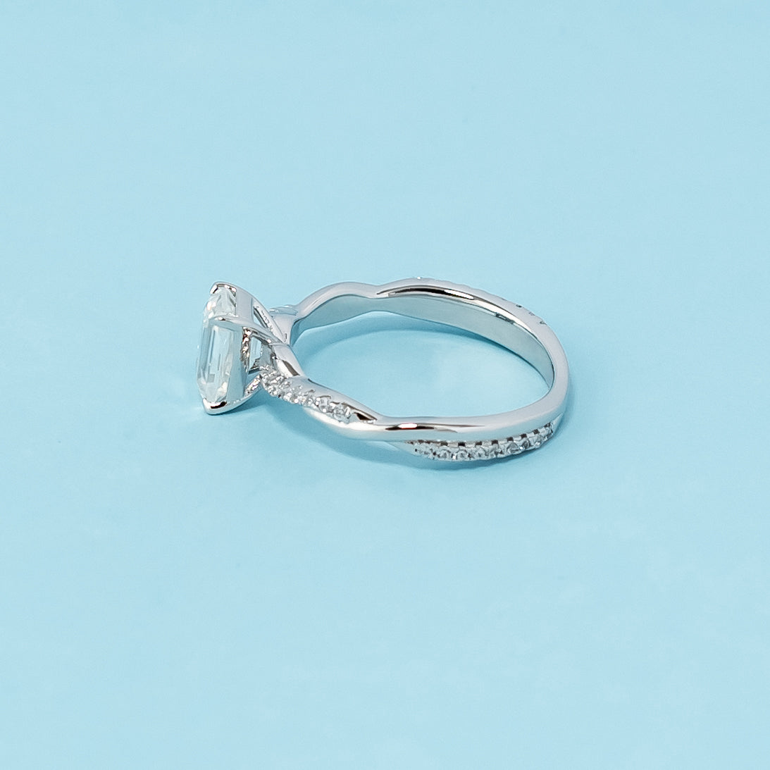 Classic and sophisticated engagement ring showcasing an emerald cut moissanite in a symbolic infinity setting, crafted in 9ct white gold.