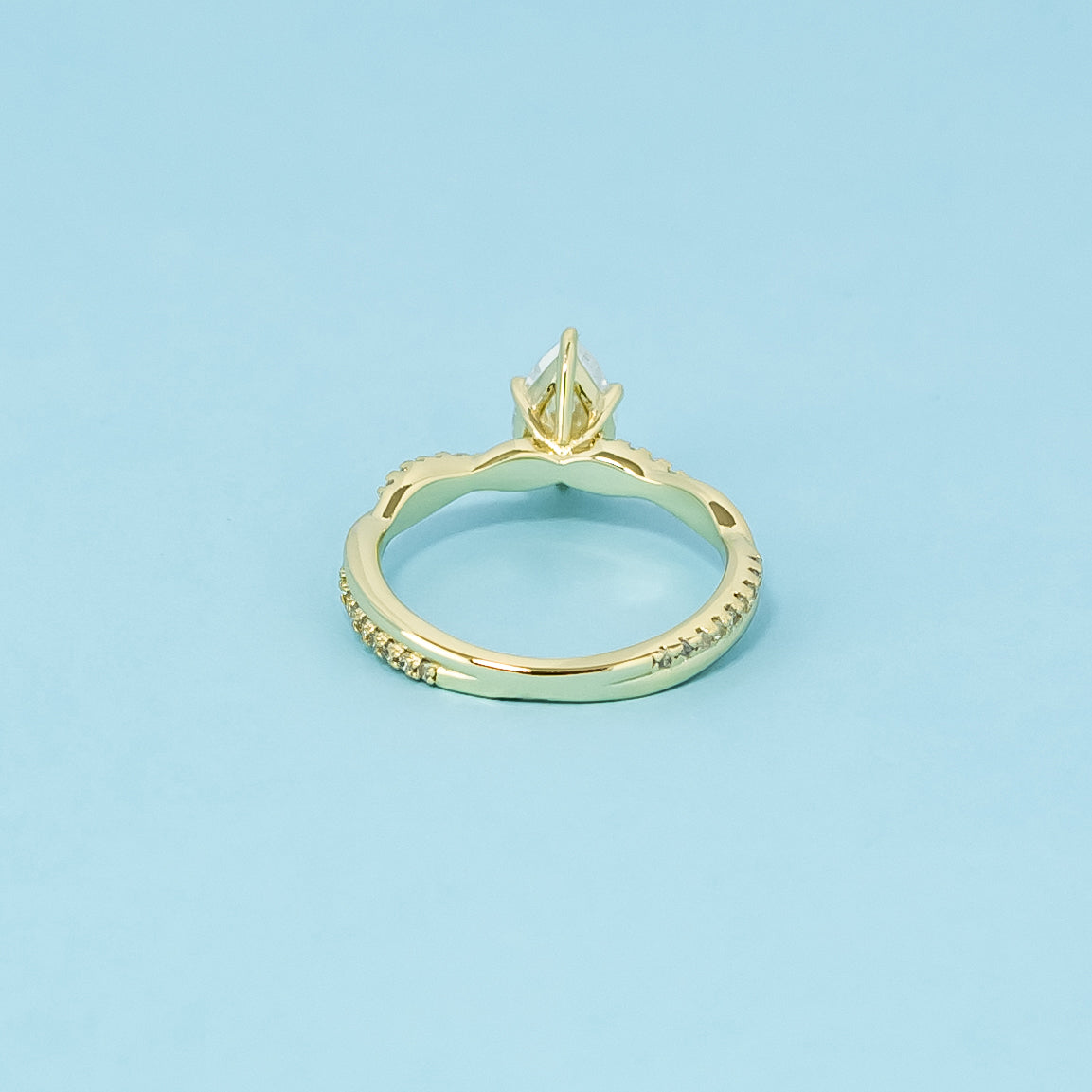 A symbol of everlasting love, this 9ct yellow gold ring features a pear-shaped moissanite and a flowing infinity design.
