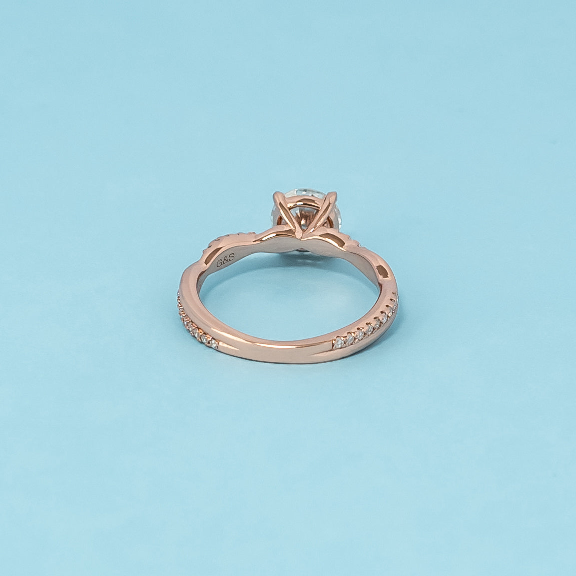 Luxurious 9ct rose gold engagement ring showcasing a beautiful round brilliant moissanite in a timeless infinity setting.