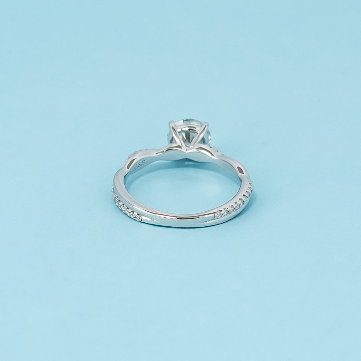 A sophisticated engagement ring combining the brilliance of a round brilliant moissanite with the symbolic design of an infinity band, crafted in 9ct white gold.