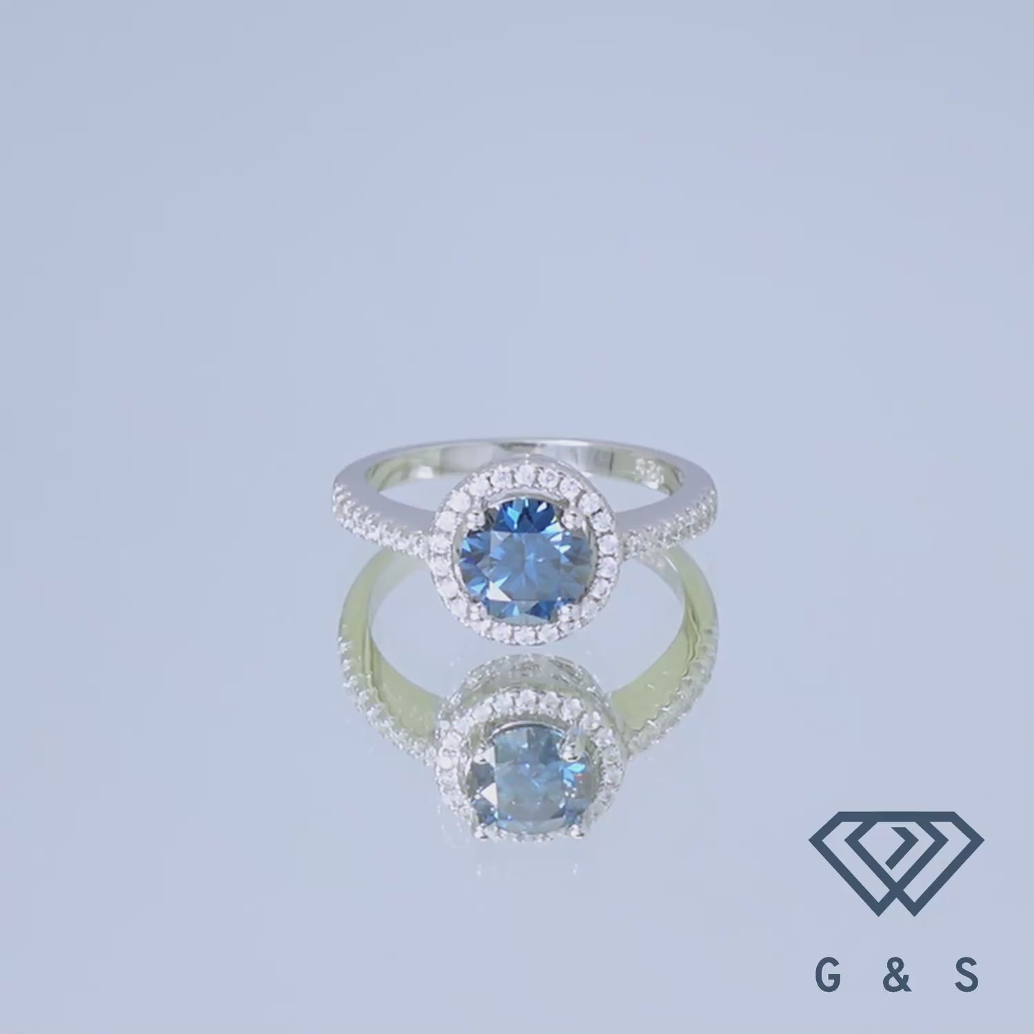 A unique engagement ring featuring a 1.00ct blue moissanite and a romantic heart-shaped halo design, crafted in sterling silver.